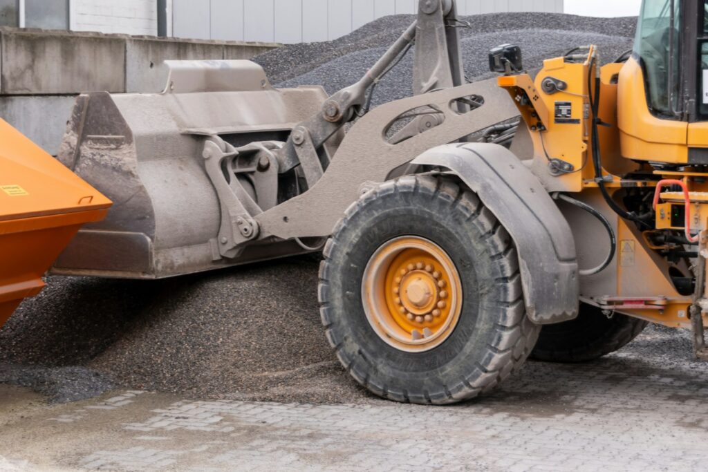 Yellow wheel loader scooping gravel at a quarry
